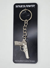 Sparta Pewter gun-shaped keychain on a black card with brand name.